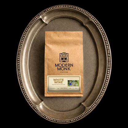 Modern Monk White Wine on a silver tray against a black background